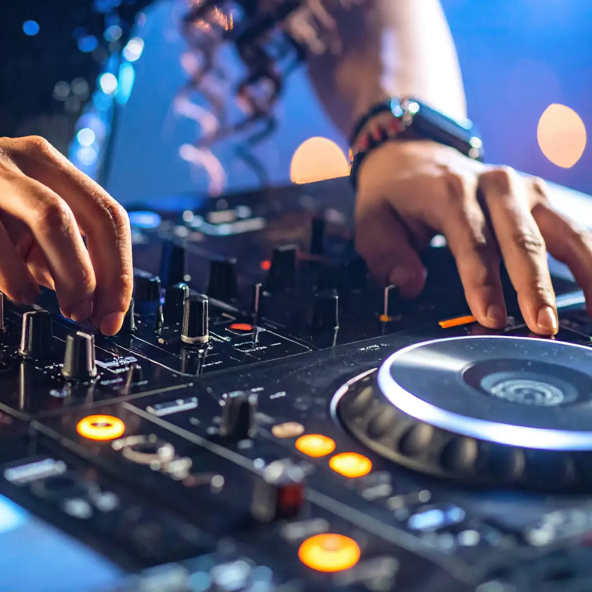 Nærbilde av hender på et DJ konsoll